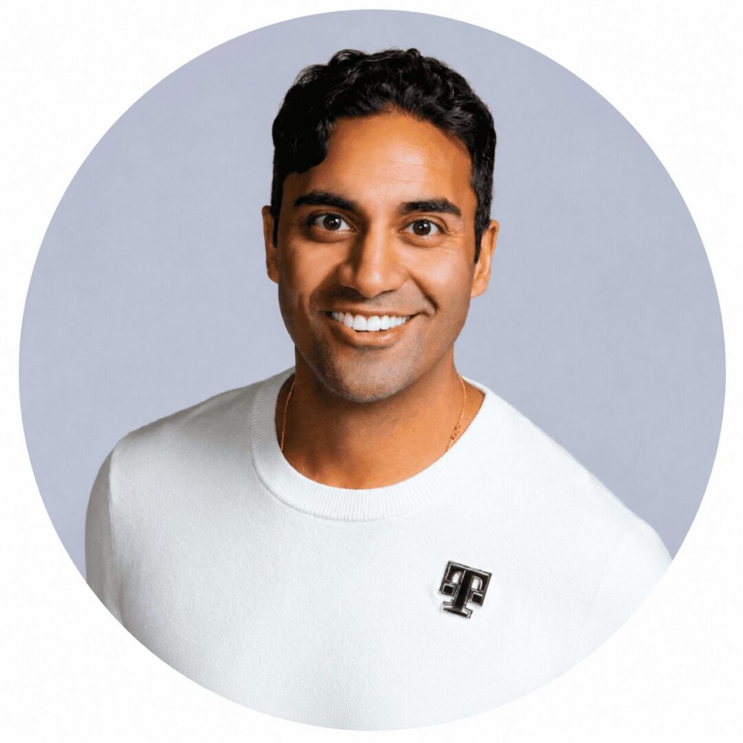 Smiling man in white sweater with T pin